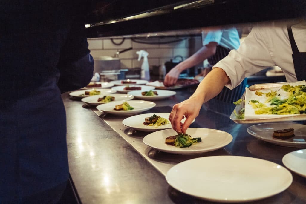 Closeup shot of the chefs preparing a fine dinner at the kitchen in a restaurant in London, England