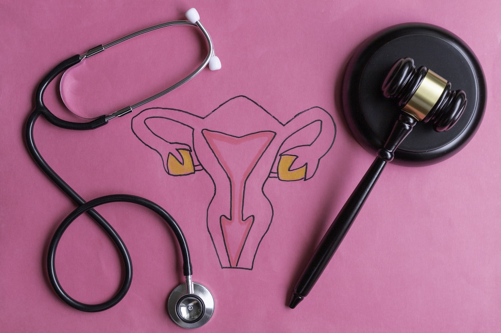 Drawing of female reproductive system with judge's gavel and stethoscope